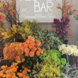 Assorted flower display with roses, chrysanthemums, and tall branches