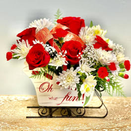 Red roses and white daisies in a decorative container with a ribbon