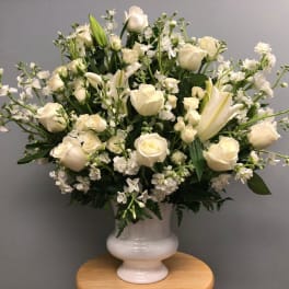 White roses and lilies arranged in a white vase