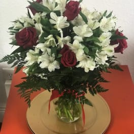 Bouquet of red roses and white alstroemeria in a glass vase