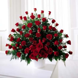 Large bouquet of red roses with greenery in a white vase