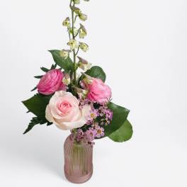 Pink and white roses in a pink glass vase