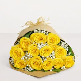 Bouquet of yellow roses wrapped in brown paper