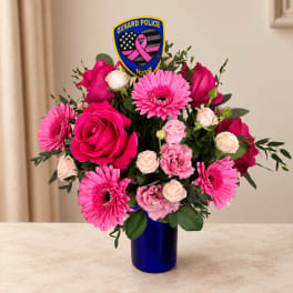 Pink roses and gerbera daisies in a blue vase with a police patch pick