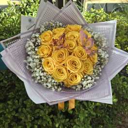 Bouquet of yellow roses with baby's breath in lavender wrap