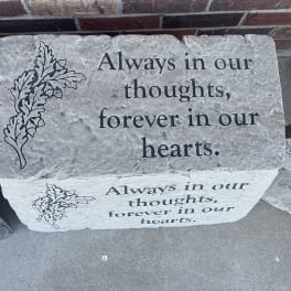 Memorial stone engraved with the words "Always in our thoughts, forever in our hearts."
