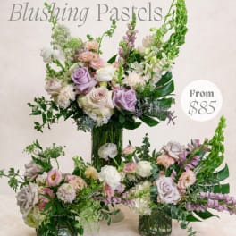 Pastel floral arrangement with roses, lisianthus, and snapdragons in a glass vase