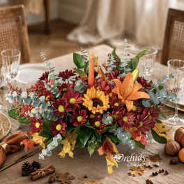 Autumn centerpiece with orange lily and red daisies on a dining table