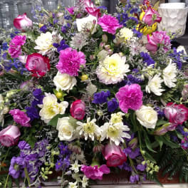 Large casket spray with pink, white, and purple flowers