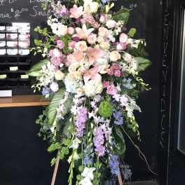 Large standing floral spray with pink lilies, roses, and purple flowers