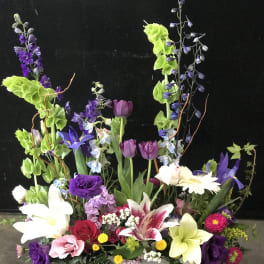 Tall mixed floral arrangement in a white rectangular container