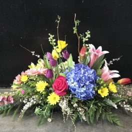 Colorful floral centerpiece with hydrangea, roses, lilies, and daisies