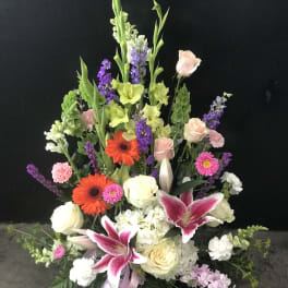 Tall mixed floral arrangement with lilies, roses, and gerbera daisies