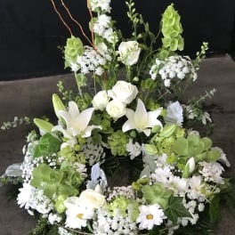 Large white and green floral wreath with roses and lilies
