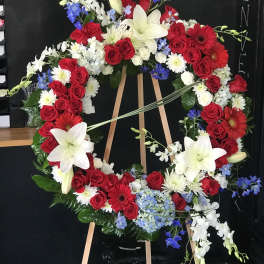 Large red, white, and blue floral wreath on an easel