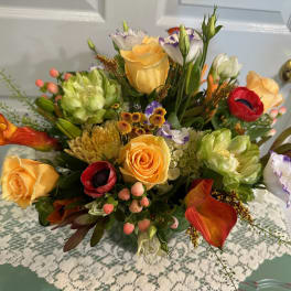 Mixed bouquet with yellow roses, red anemones, and orange calla lilies