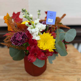 Mixed bouquet in a red vase with yellow, white, and red flowers