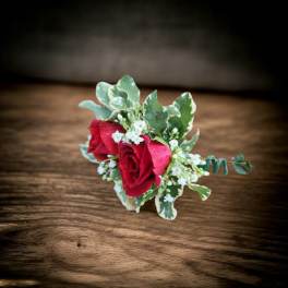 Small boutonniere with red roses and white filler flowers