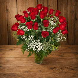 Bouquet of red roses and white baby's breath in a clear glass vase