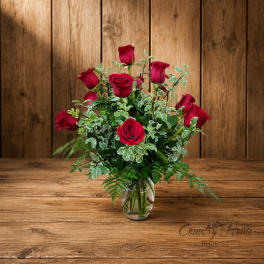 Red roses arranged in a clear glass vase