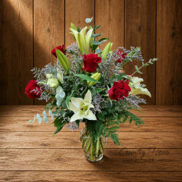Red roses and white lilies arranged in a clear glass vase