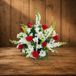 Bouquet of red roses and white daisies with white lilies in a low arrangement
