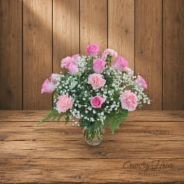 Pink roses and carnations in a clear glass vase