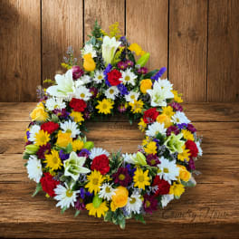 Colorful floral wreath with daisies, roses, lilies, and carnations