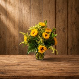 Sunflower bouquet in a clear glass vase on a wooden table