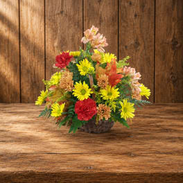 Basket arrangement of yellow, red, and peach flowers
