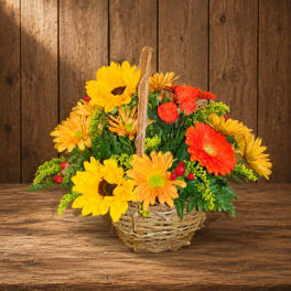 Basket arrangement of yellow and orange flowers with red accents