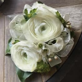 White ranunculus bouquet with silver ribbon and small green accents