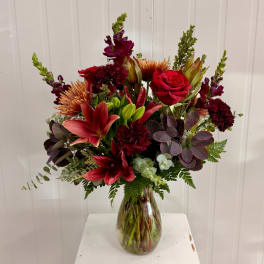 Mixed red and burgundy bouquet in a glass vase