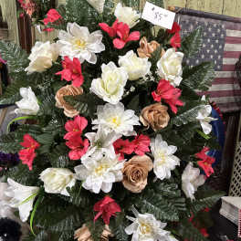 Artificial floral arrangement with white, red, and tan blooms in a dense display