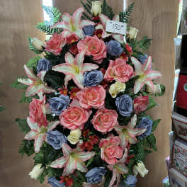 Large standing floral spray with pink lilies, roses, and blue roses