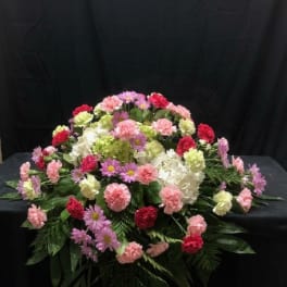 Large floral spray with pink, white, and red carnations and daisies