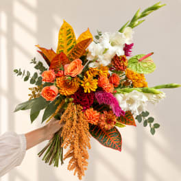 Handheld bouquet with orange, white, and yellow flowers