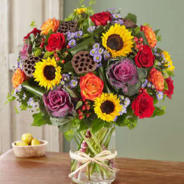 Mixed bouquet of roses and sunflowers in a glass vase
