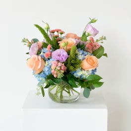 Pastel mixed flower arrangement in a clear glass vase