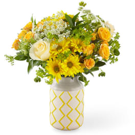 Yellow and white flower bouquet in a patterned ceramic vase