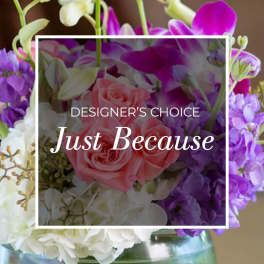 Pink roses and purple orchids in a glass vase with "Just Because" text overlay