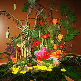 Large tropical floral arrangement with bright mixed blooms and branches