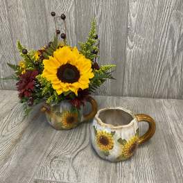 Sunflower arrangement in a sunflower mug beside an empty matching mug