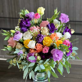 Mixed bouquet of roses and lisianthus in a glass vase
