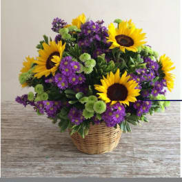 Basket arrangement of sunflowers, purple daisies, and green button mums