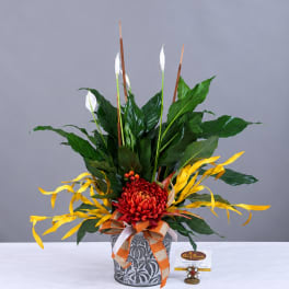 Red chrysanthemum arrangement in a patterned pot with white blooms and yellow ribbon accents