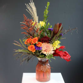 Mixed bouquet in a ribbed glass vase with orange roses and a peach chrysanthemum