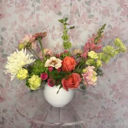 Mixed bouquet in a white vase with pink, orange, and white blooms