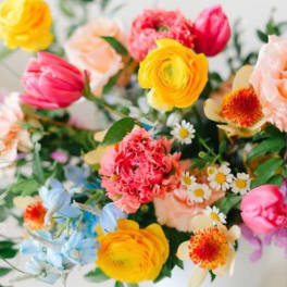 Colorful mixed bouquet with yellow, pink, peach, and blue flowers