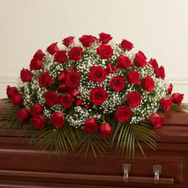 Red roses arranged on a casket with white baby's breath